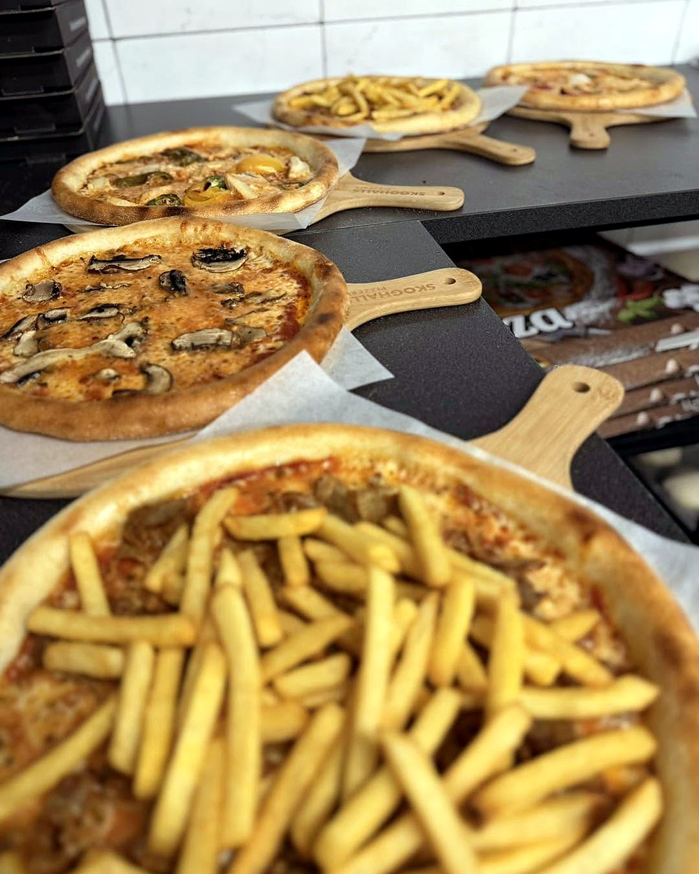 Nygräddade pizzor på Skoghalls pizzabrädor, en Pizza Frites med pommes närmast